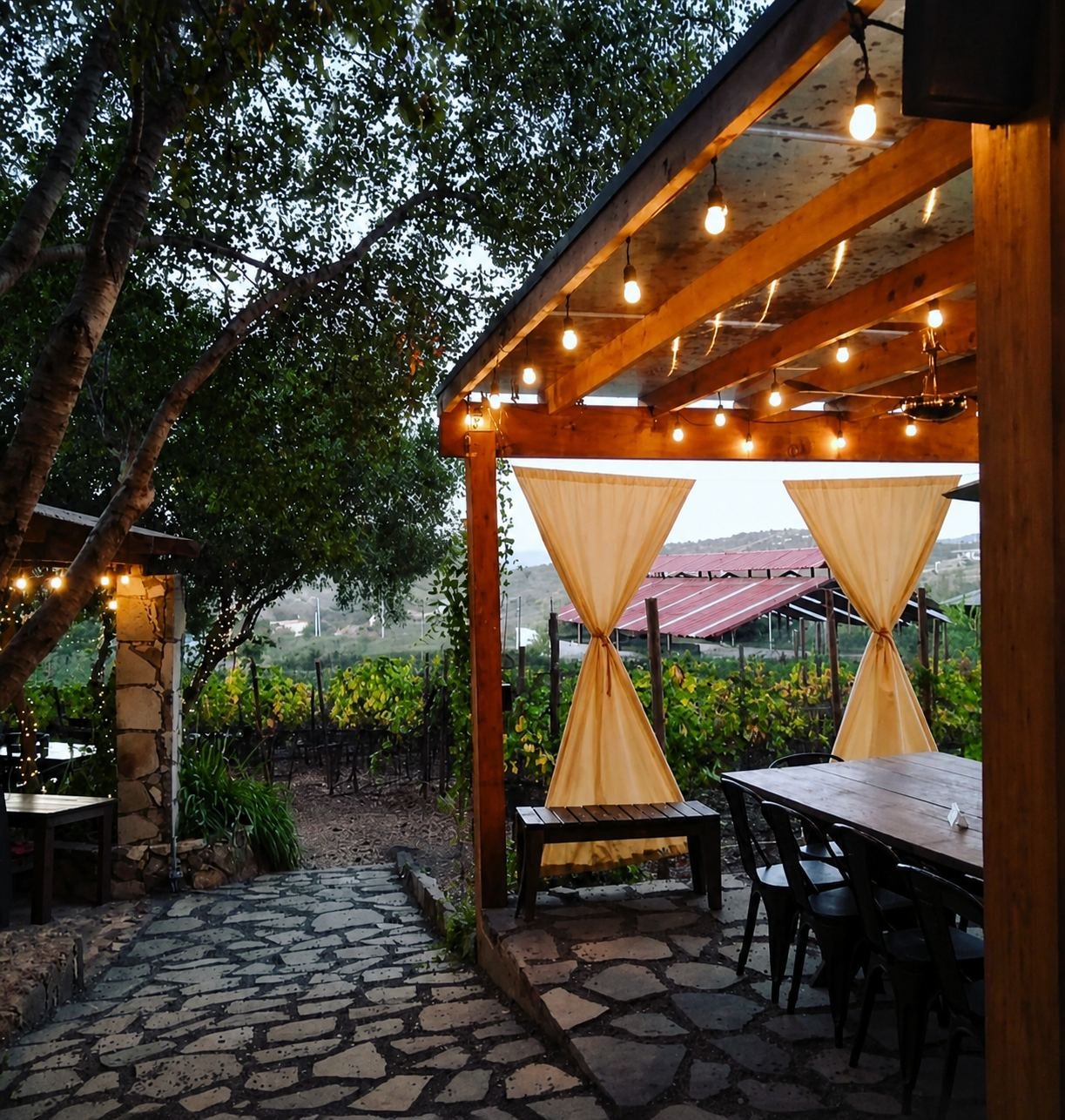 Terraza de Asador Nativo entre encinos y viñedos